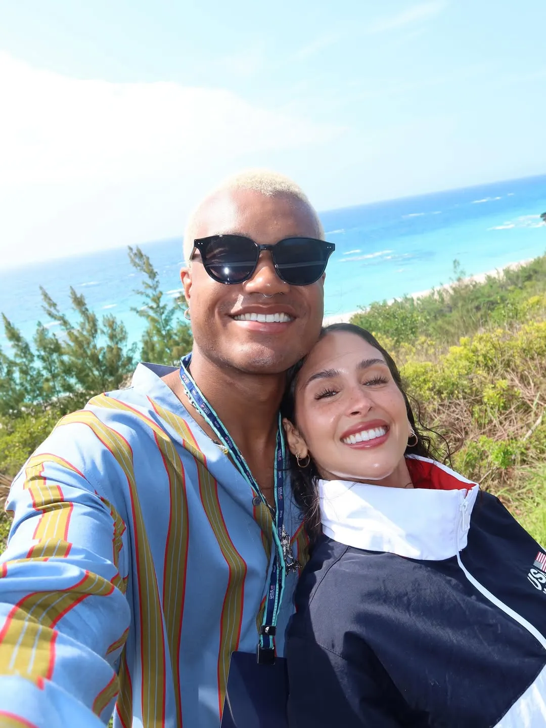 KJ Dillard taking a selfie with Dara Levitan, with an ocean view in the background.