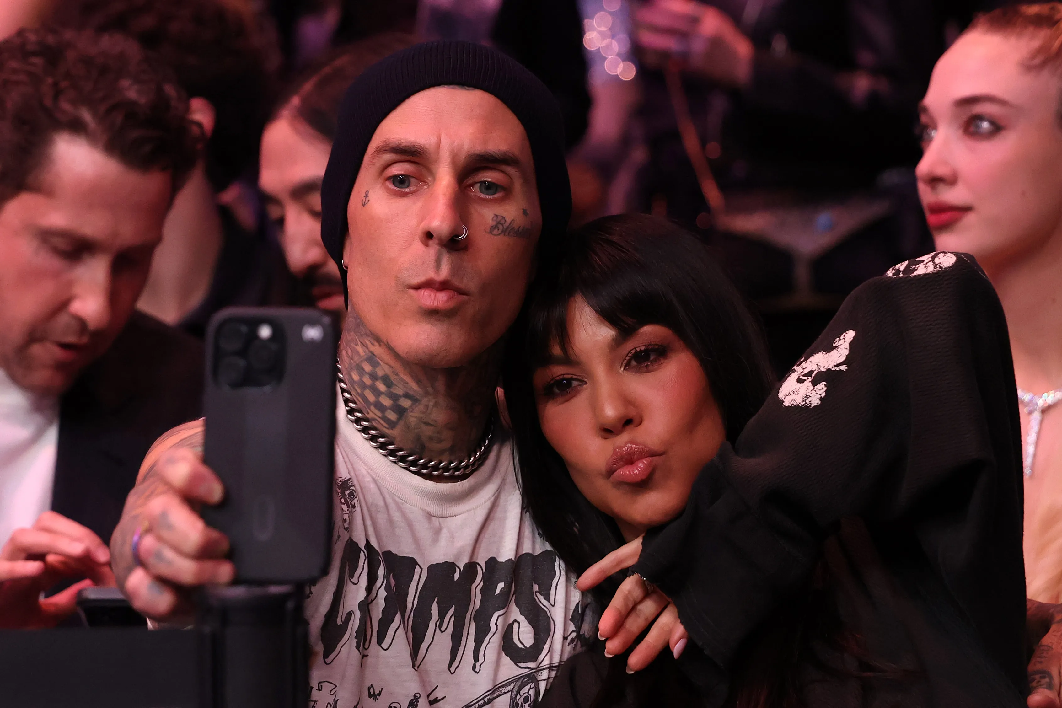 Travis Barker taking a selfie with Kourtney Kardashian making a kissy face.