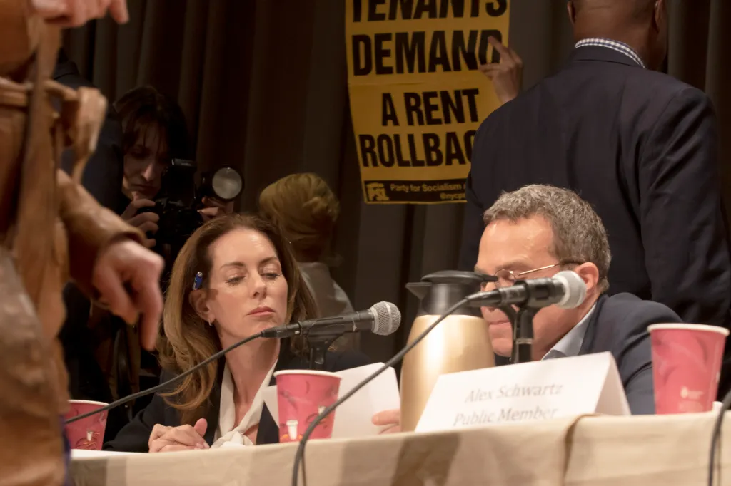 Landlord representatives Christina Smyth and Rober Erlich surrounded by tennant groups as they occupy the stage as the Rent Guildelines Board met at Copper Union in Manhattan and agreed to a preliminary raise in rents.