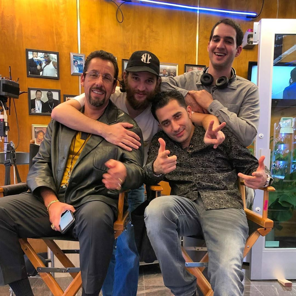 Adam Sandler, Josh Safdie, Maksud Agadjani, and Benny Safdie posing together on the set of Uncut Gems.