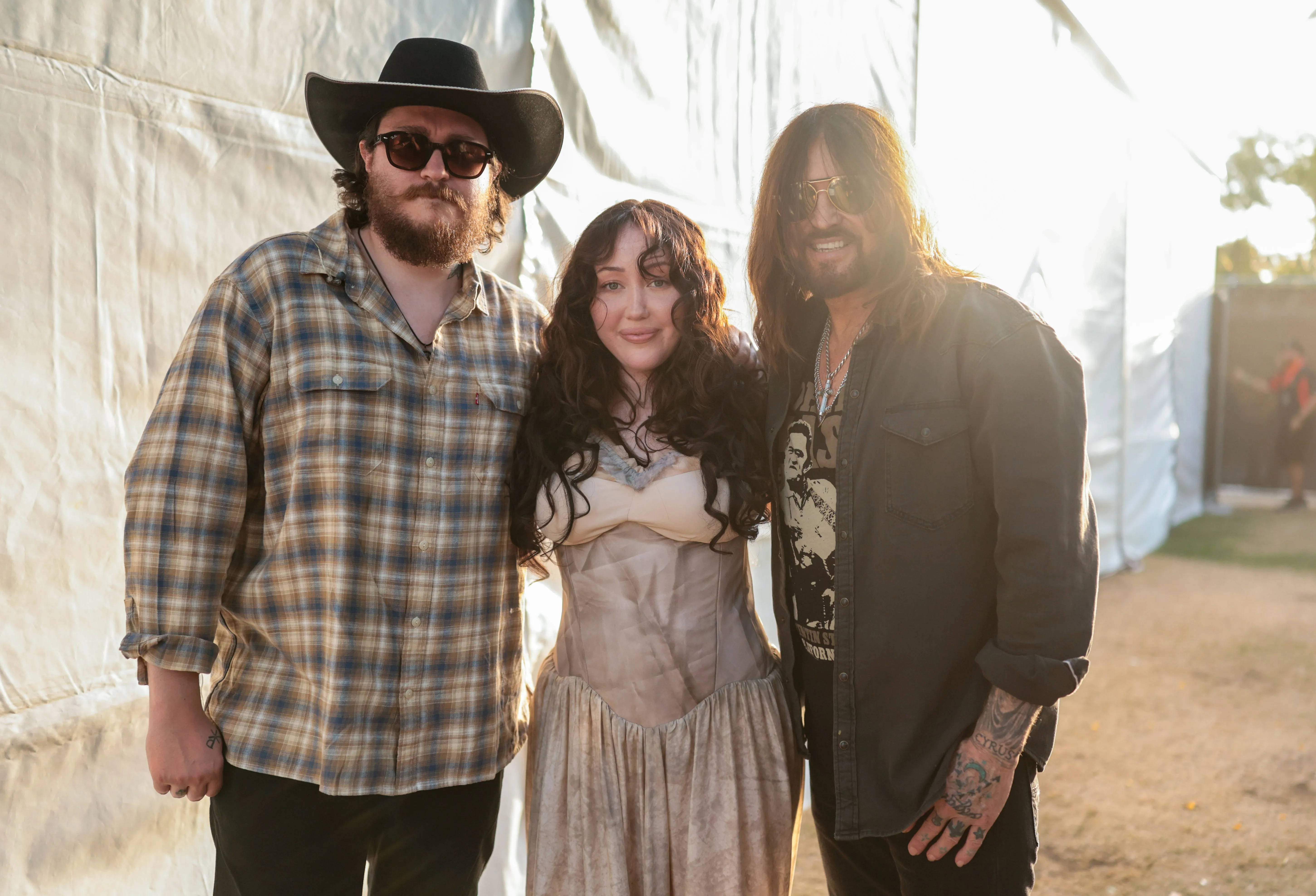 Braison Cyrus, Noah Cyrus, and Billy Ray Cyrus posing for a portrait backstage.