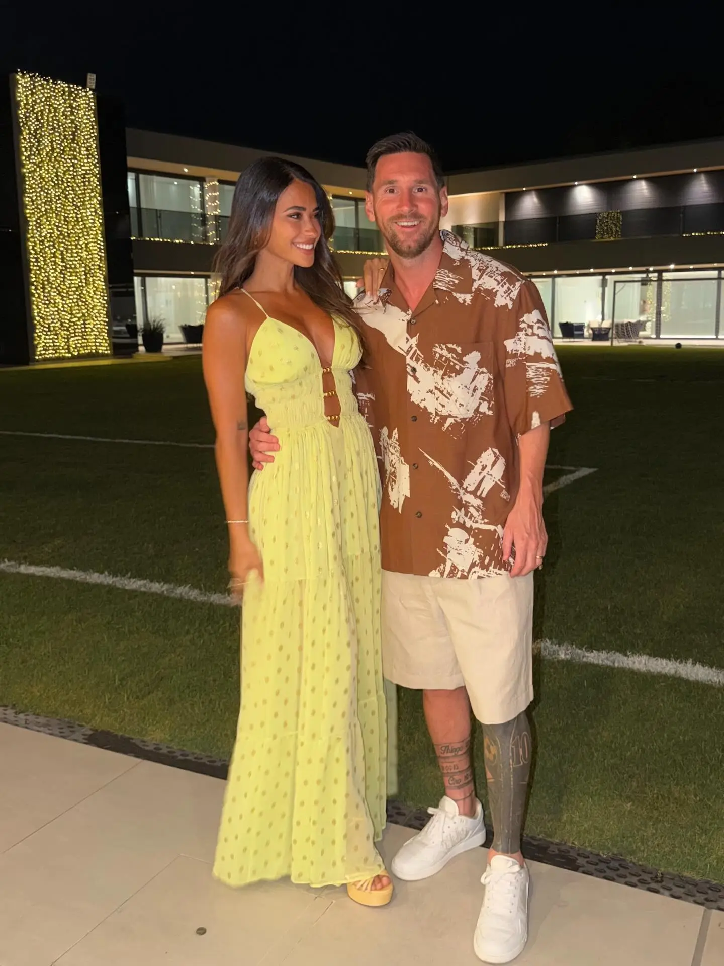 Lionel Messi and Antonella Roccuzzo posing together at night.