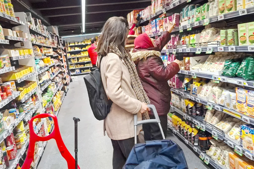 People shopping in a supermarket aisle.
