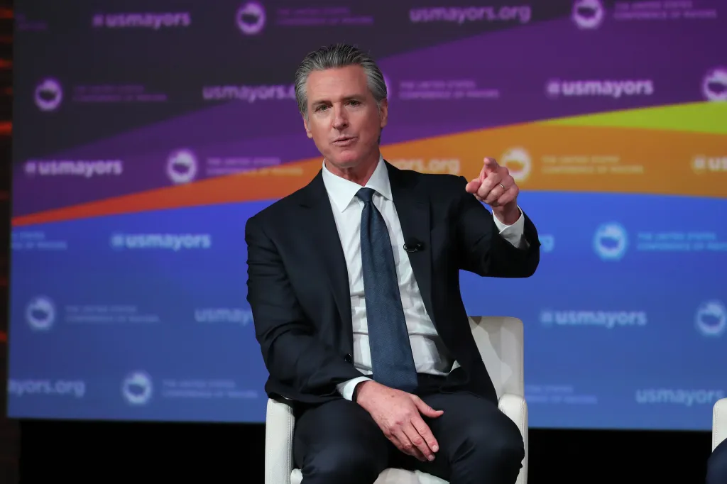 California Governor Gavin Newsom speaking and pointing at the U.S. Conference of Mayors' 94th Annual Meeting.