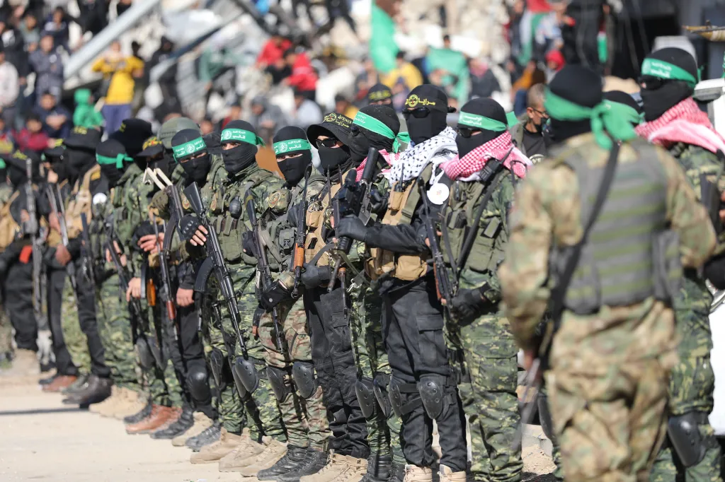 Members of the Al-Qassam Brigades and Al-Quds Brigades stand in formation.