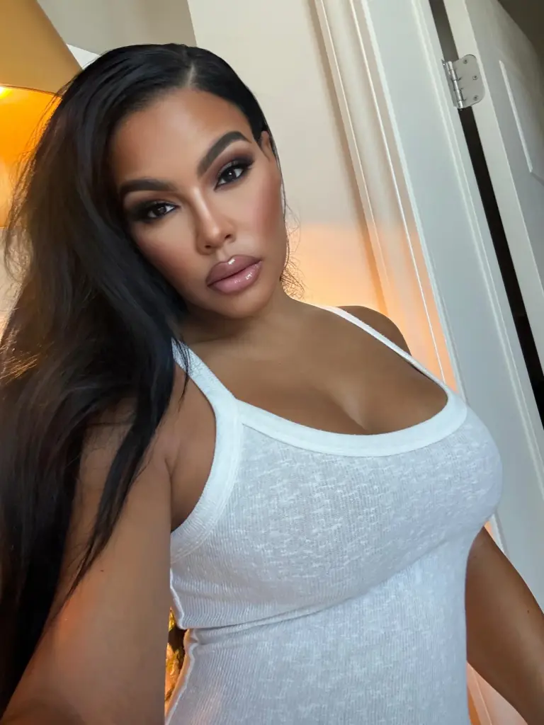 Mia Thornton posing in a white tank top.