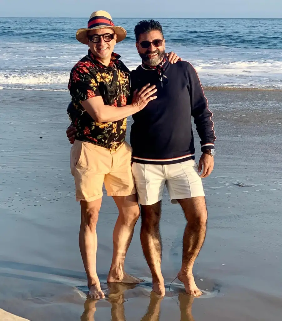 Zafar Padamese Mawani and Guillermo Jafett Hidalgo Ortiz embracing on a beach.