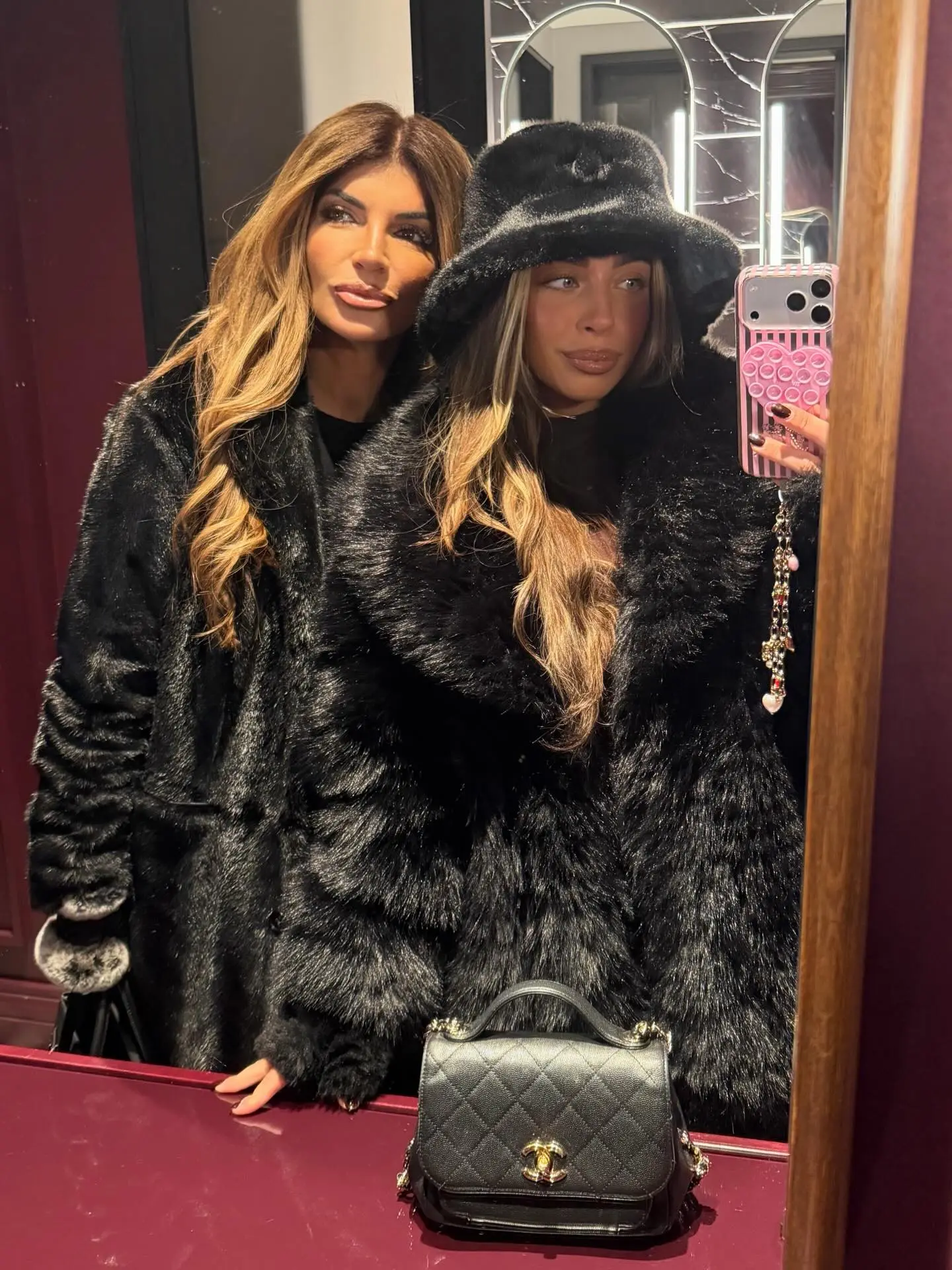 Teresa and Gia Giudice taking a selfie in black fur coats.