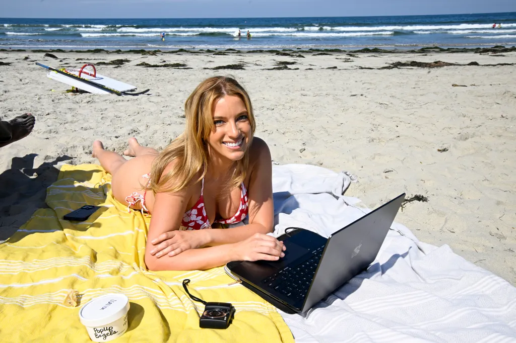 Nadia Nowak works on her laptop on the beach in Pacific Beach.