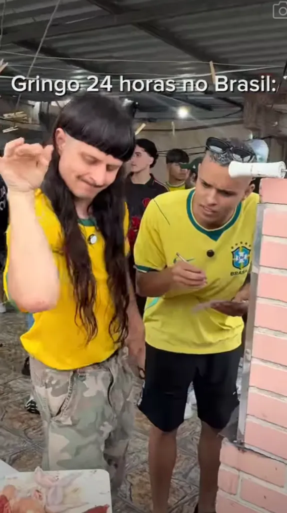Two men wearing yellow Brazil soccer jerseys, one with a mullet haircut, are in an outdoor setting with raw chicken on a table, with text that translates to "Gringo 24 hours in Brazil".