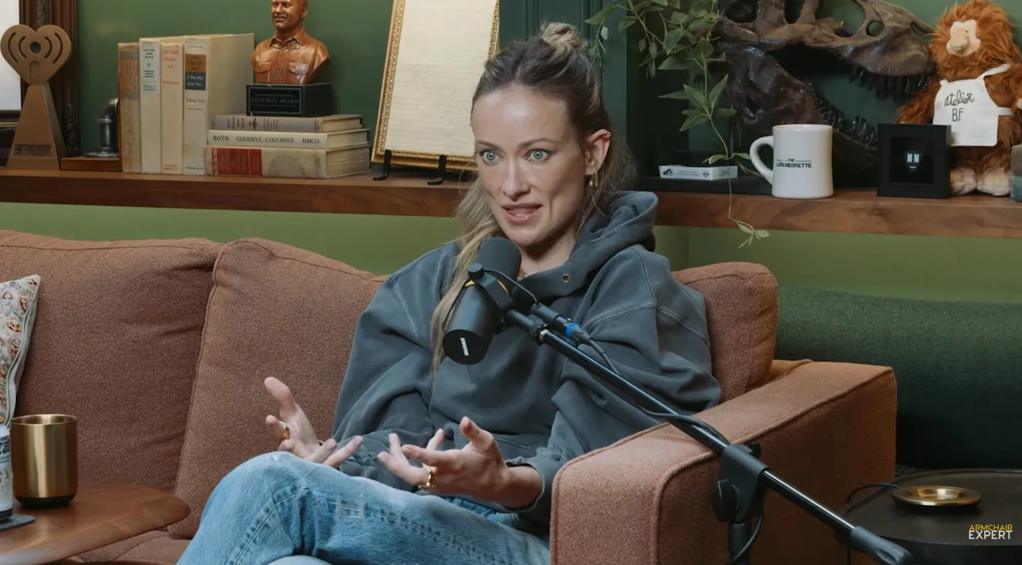 Olivia Wilde speaking into a microphone on a podcast.