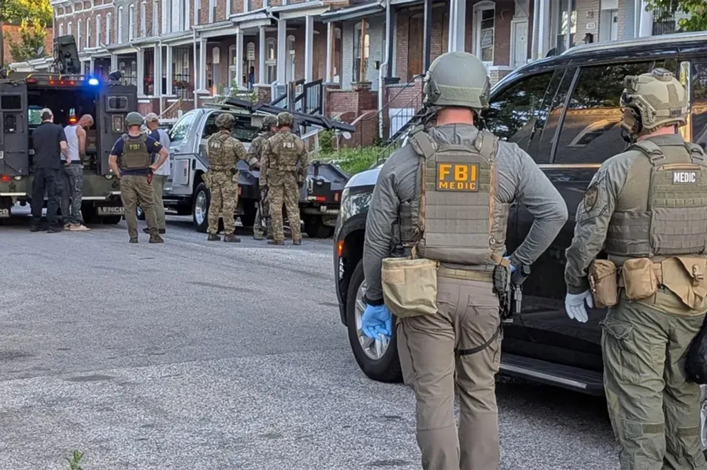 FBI agents and a Lenco BearCat armored vehicle on a street in front of row houses during "Operation Turf War".