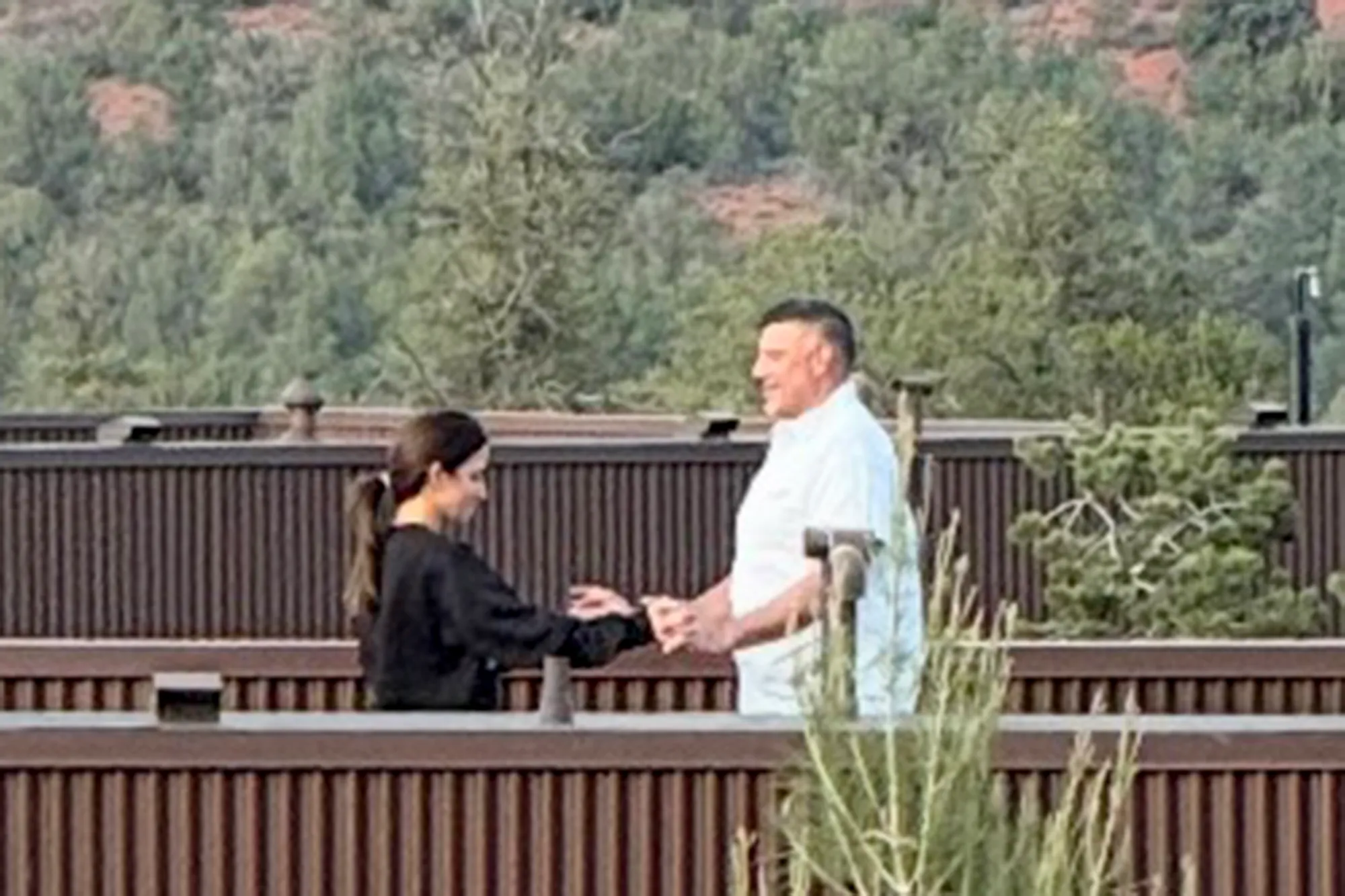 Patriots coach Mike Vrabel and reporter Dianna Russini holding hands on a balcony.