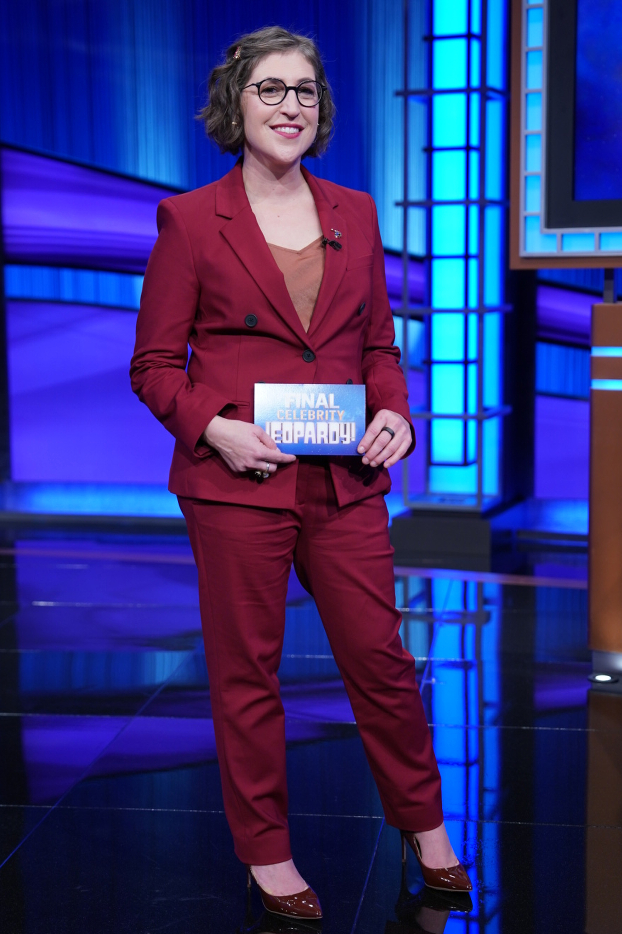 Mayim Bialik holding a "Final Celebrity Jeopardy!" card.