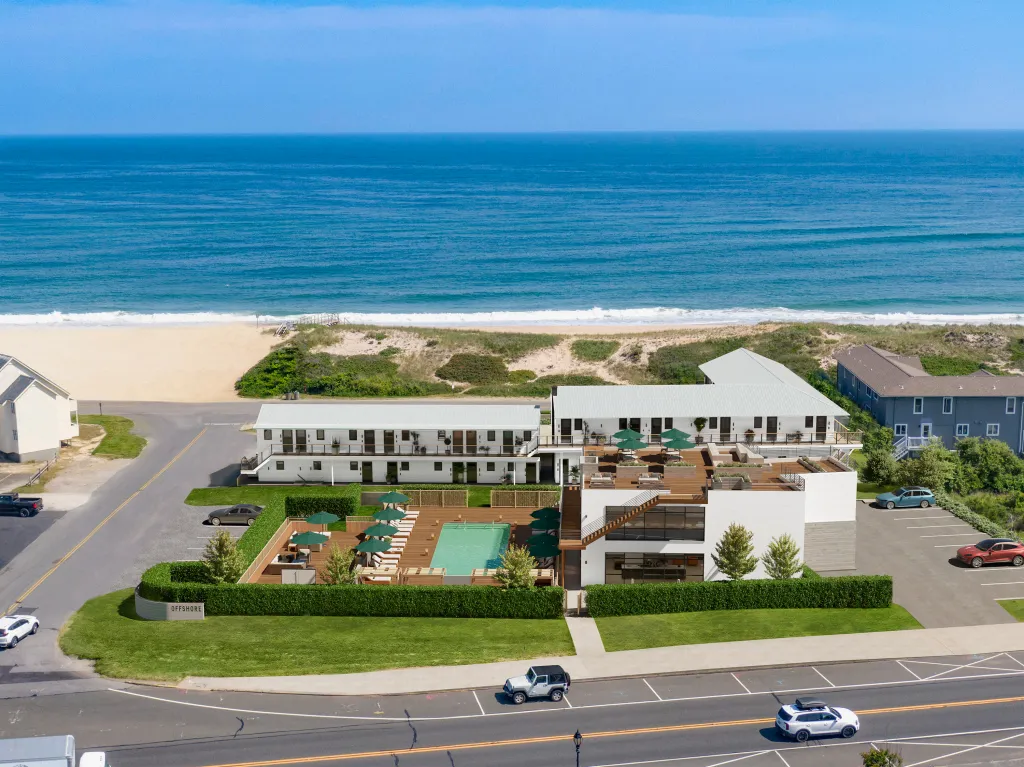 Illustration of Este, a two-story restaurant with a rooftop and pool, located near a beach with the ocean in the background.
