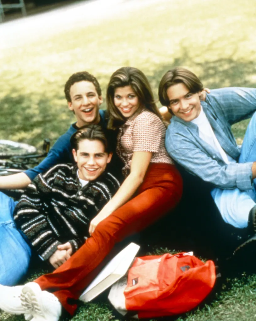 The cast of Boy Meets World, from left: Rider Strong, Ben Savage, Danielle Fishel, Will Friedle, smiling in the grass.