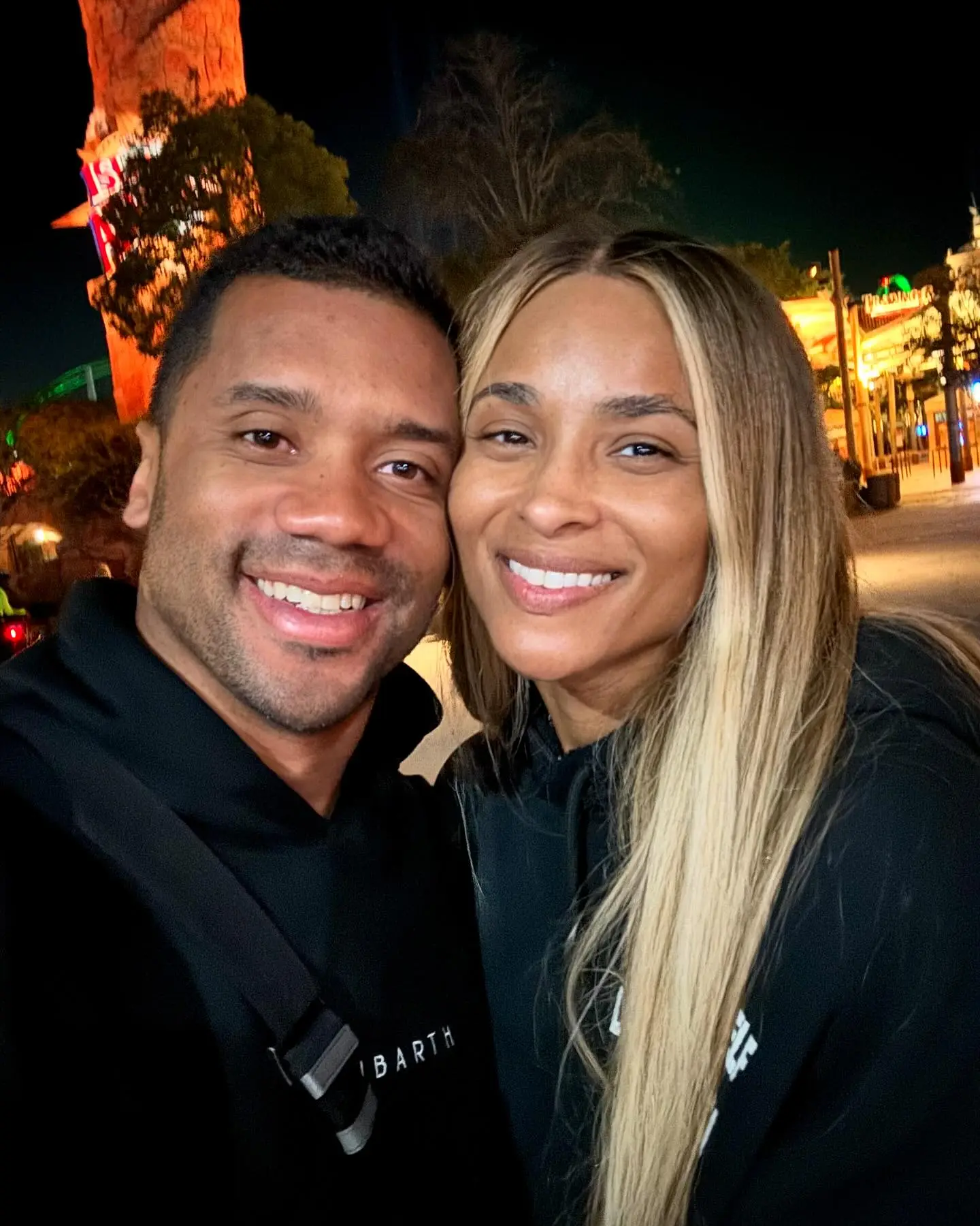 Russell Wilson and Ciara smile together.