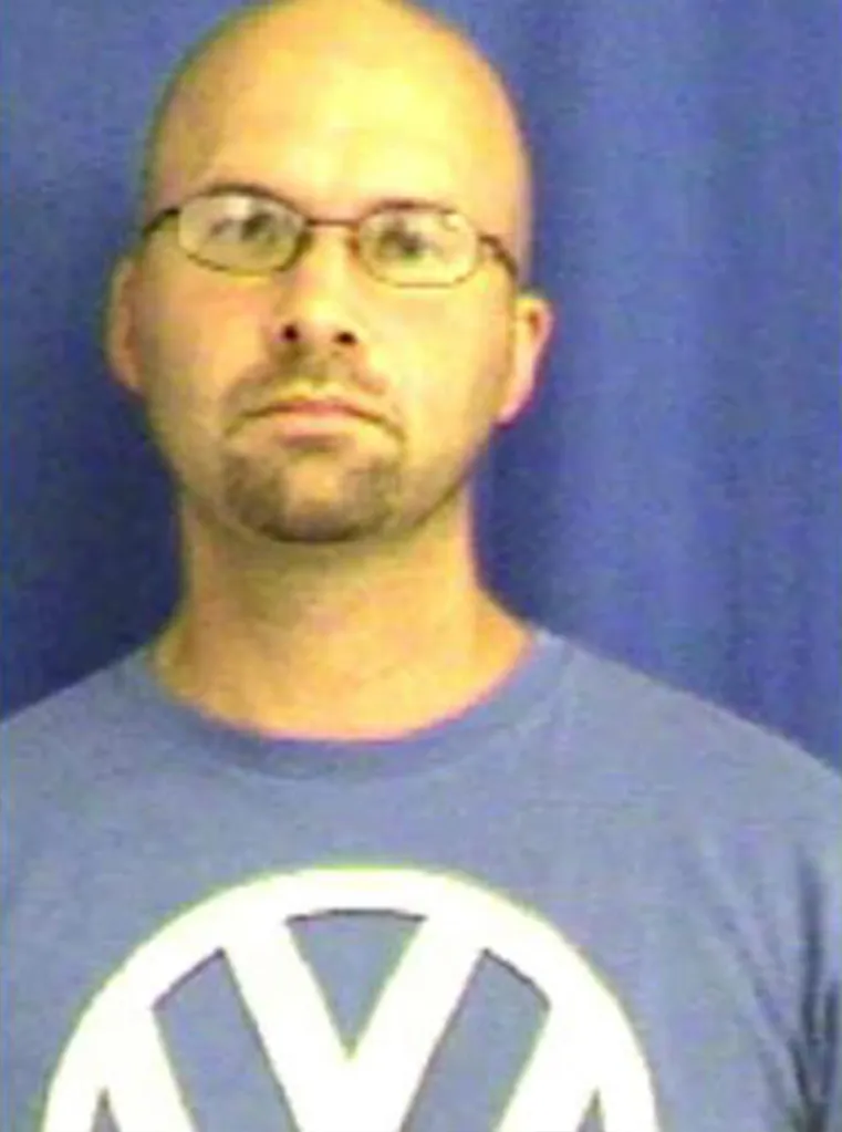 Mugshot of Ryan McFarland, a bald man with glasses and a goatee, wearing a blue t-shirt with a white Volkswagen logo.