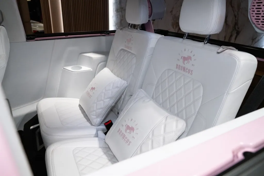 Interior of a white Ford Bronco with "Vintage Broncos" embroidered on the seats and pillows.