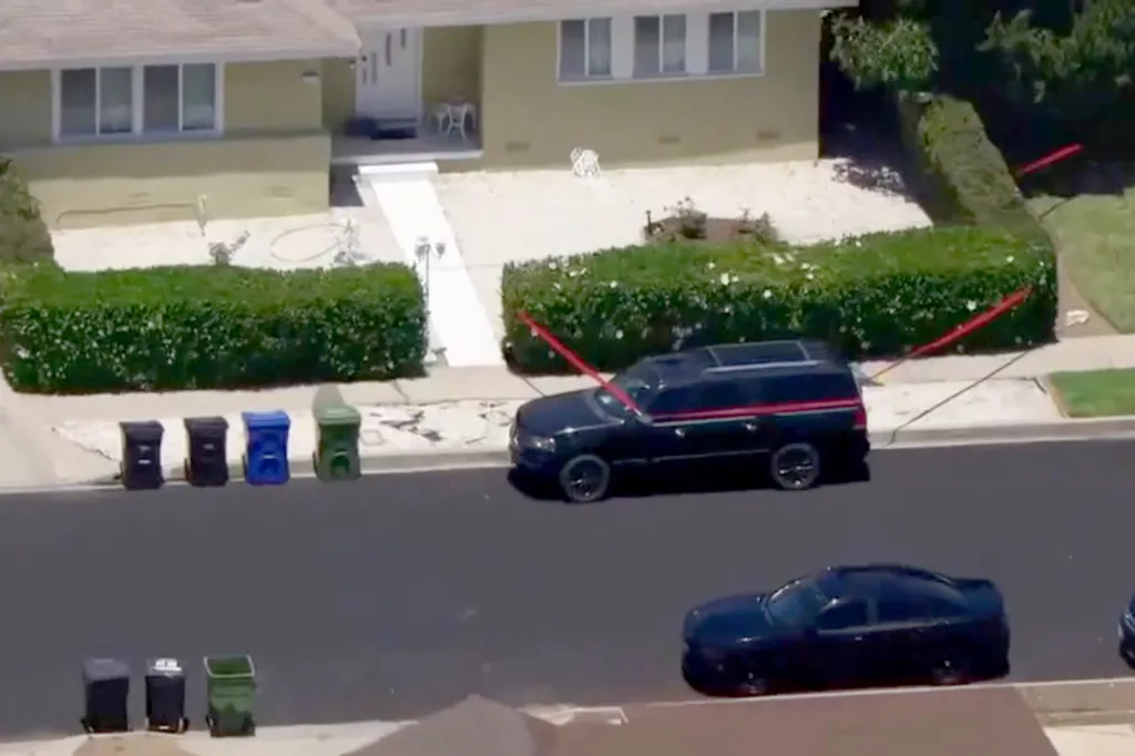 Crime scene tape around a home in Tarzana, with a black SUV parked in front.