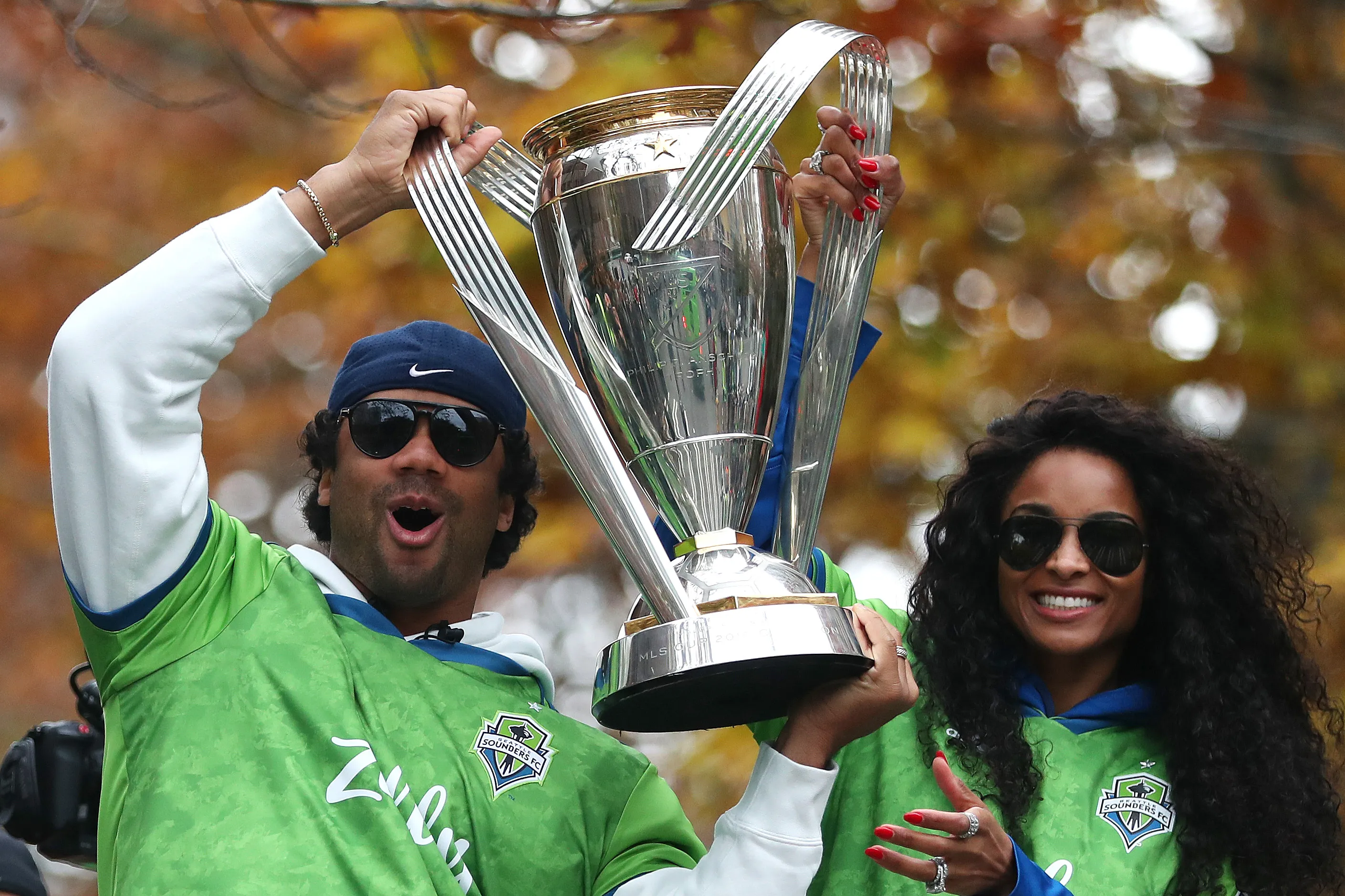 Seattle Sounders part owners Russell Wilson and Ciara hold the MLS Cup trophy during a victory parade.