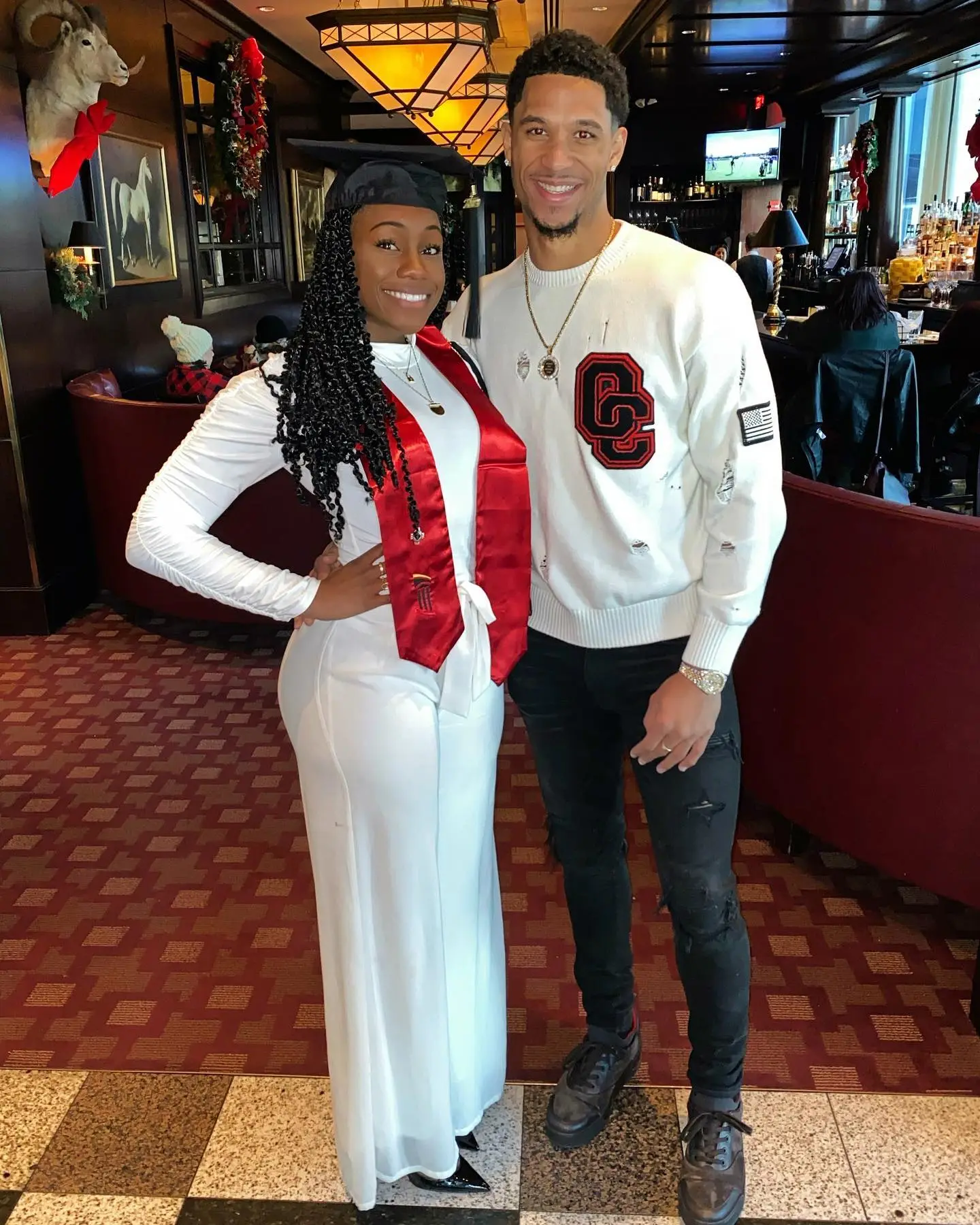 Shannon and Josh Hart posing together in a restaurant.