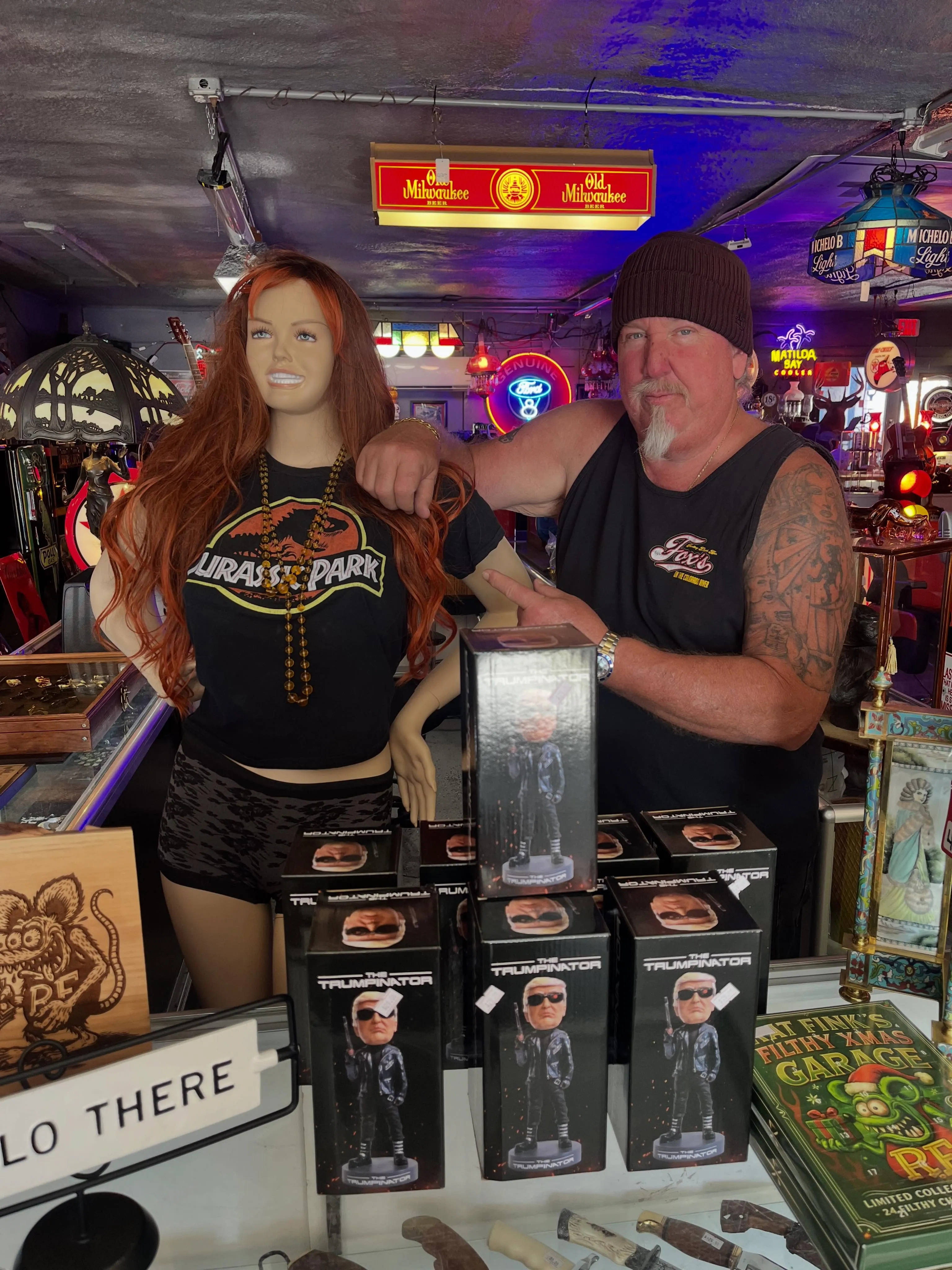Brandon Sheets standing with a female mannequin and several "The Trumpinator" bobbleheads.