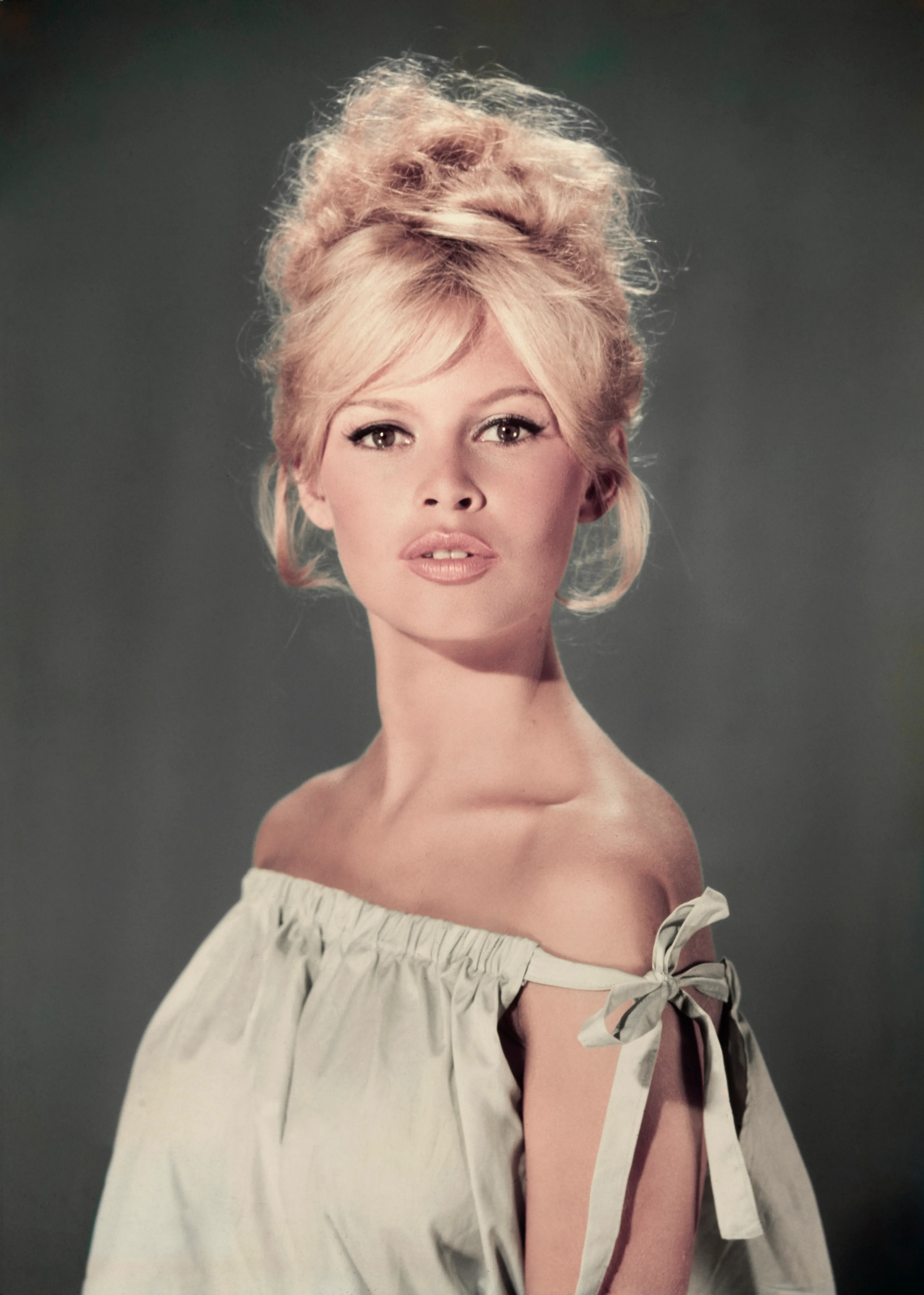 Studio portrait of actress and model Brigitte Bardot wearing a light blue off-the-shoulder dress.