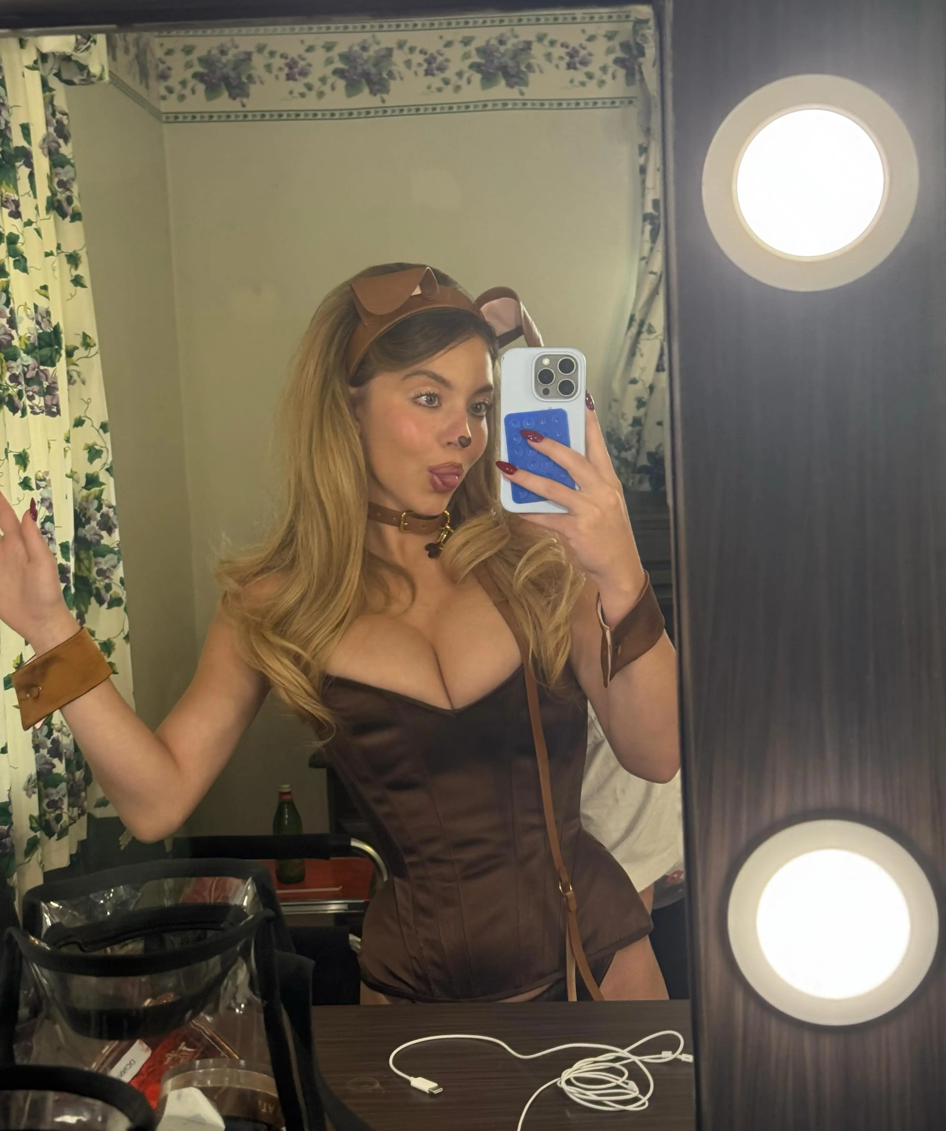Sydney Sweeney posing for a mirror selfie in a brown dog costume.