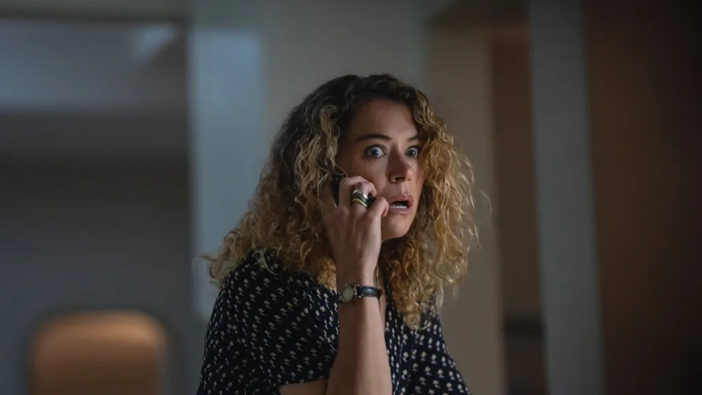 Tatiana Maslany in "Maximum Pleasure Guaranteed," holding a phone to her ear with a surprised expression.