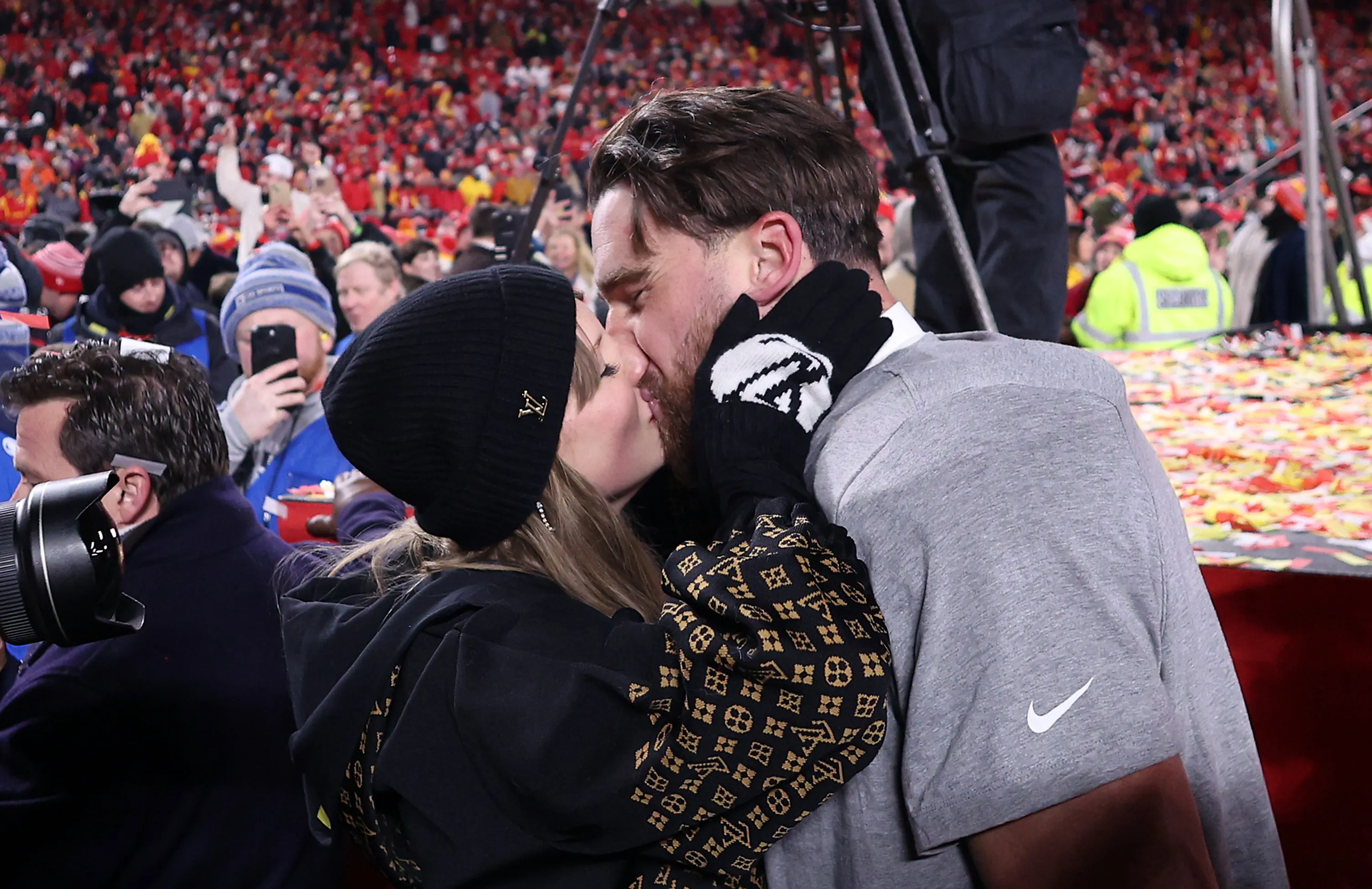 Taylor Swift kissing Travis Kelce on the field after the AFC Championship Game.