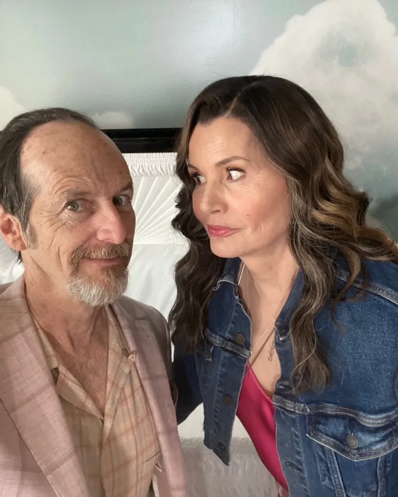 Geena Davis and Denis O'Hare in a selfie in front of a white coffin.