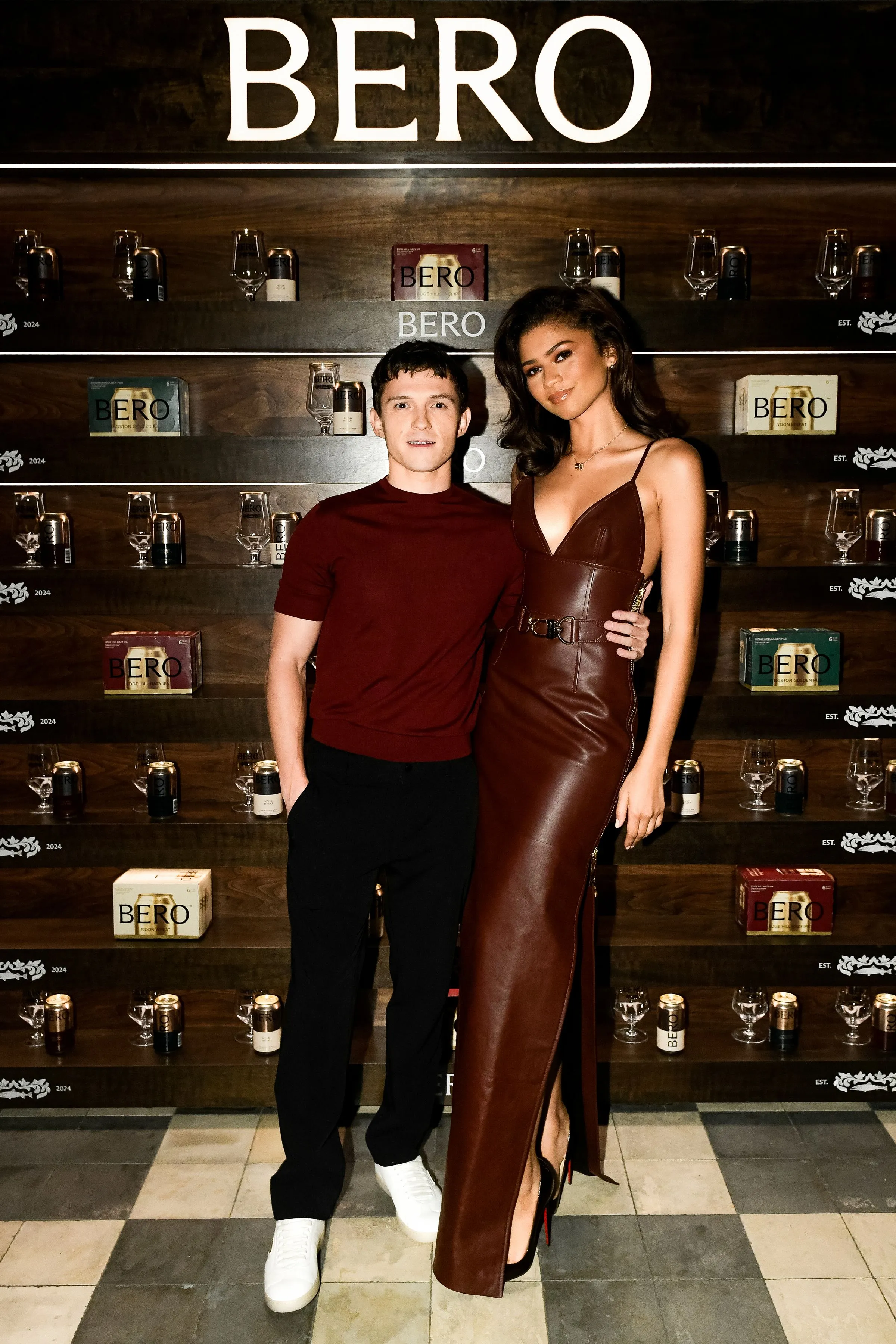 Tom Holland and Zendaya standing in front of a display of Bero products.