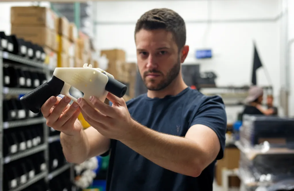 Cody Wilson, owner of Defense Distributed company, holds a 3D printed gun, called the "Liberator", in his factory in Austin, Texas on August 1, 2018.