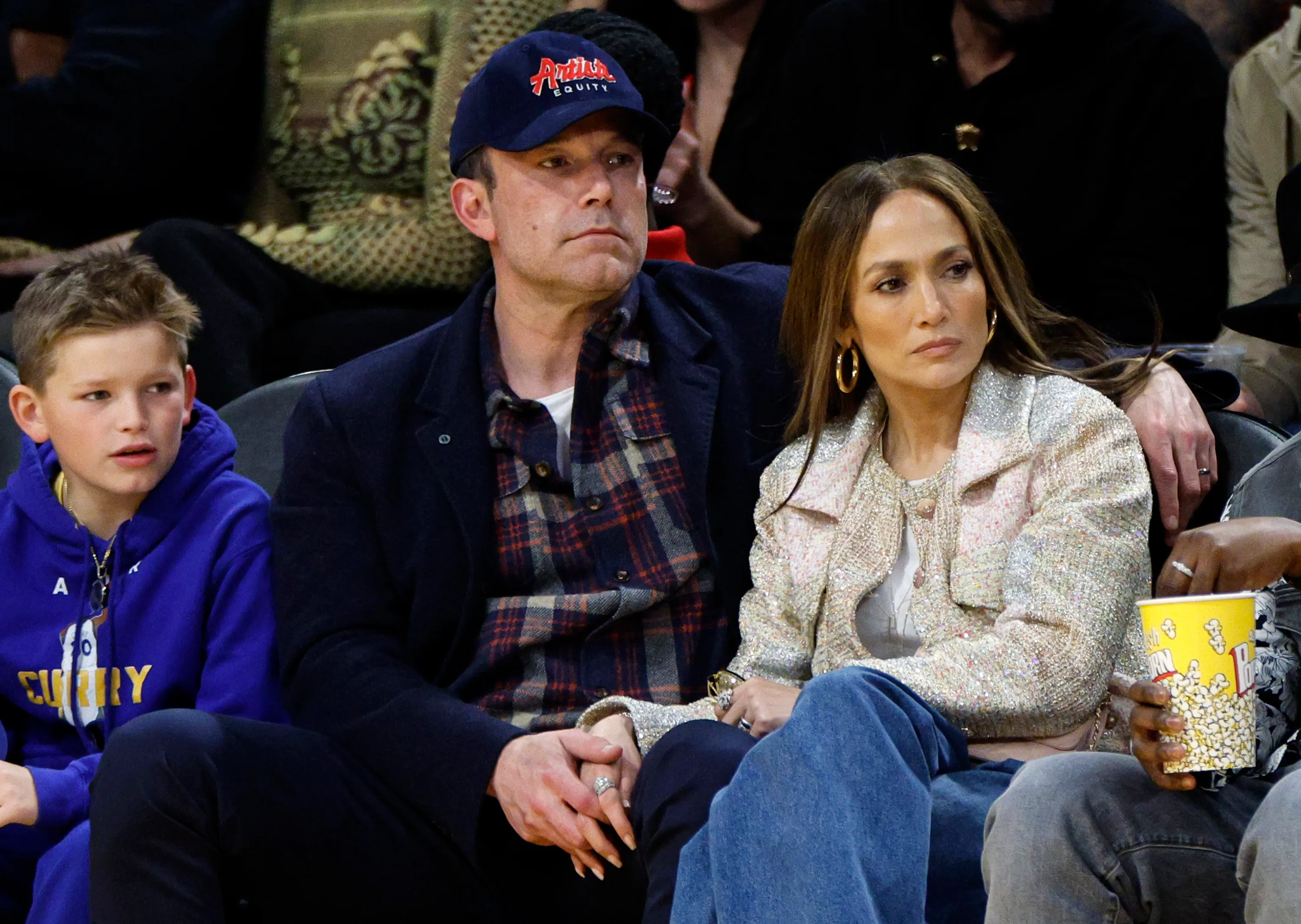 Jennifer Lopez, Ben Affleck, and his son Samuel Garner Affleck watch a basketball game.