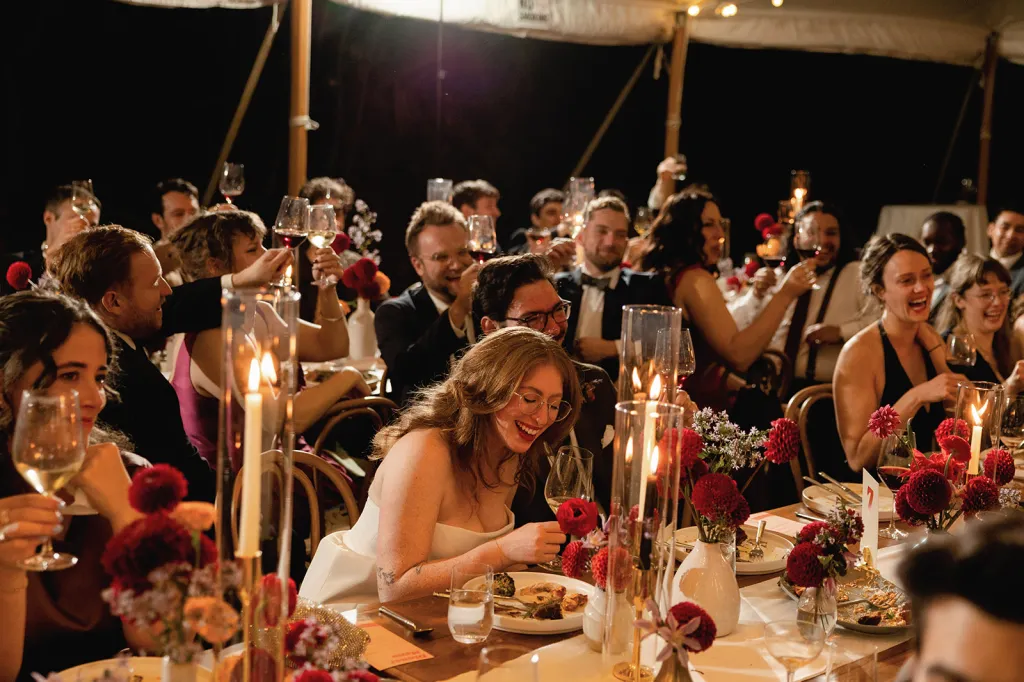 Guests laughing at a wedding reception dinner.