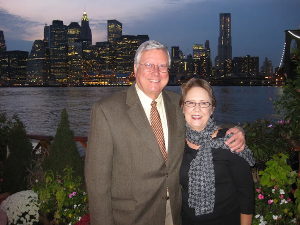 William E. Thornton and a woman smiling with the New York City skyline in the background.