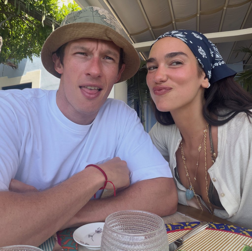 Dua Lipa and a man seated at a table.