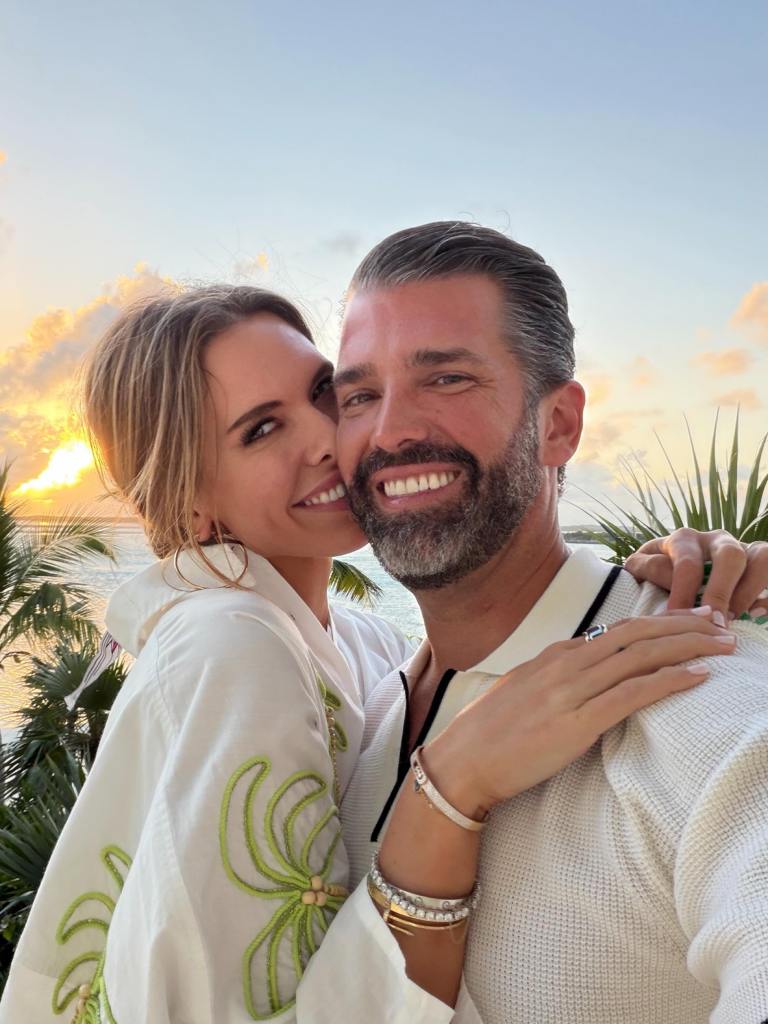 Bettina Anderson and Donald Trump Jr. posing together with a sunset in the background.