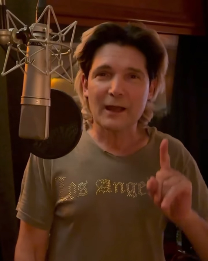 Corey Feldman speaking into a studio microphone.