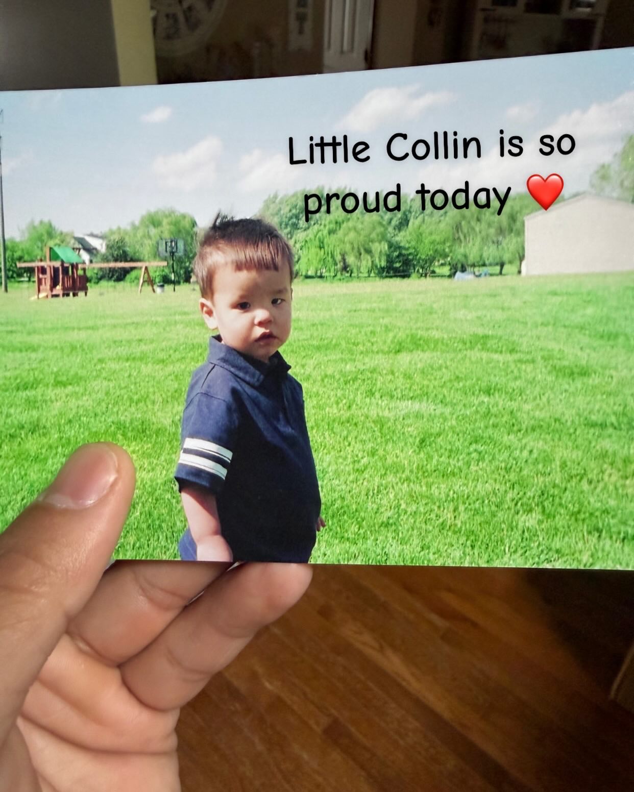 Collin Gosselin holding a photo of a young Collin in a blue polo shirt standing in a grassy field with text "Little Collin is so proud today ❤️" overlaid.