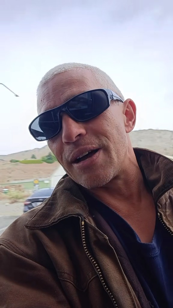 Matt Brown from Alaskan Bush People wearing sunglasses and a brown jacket.