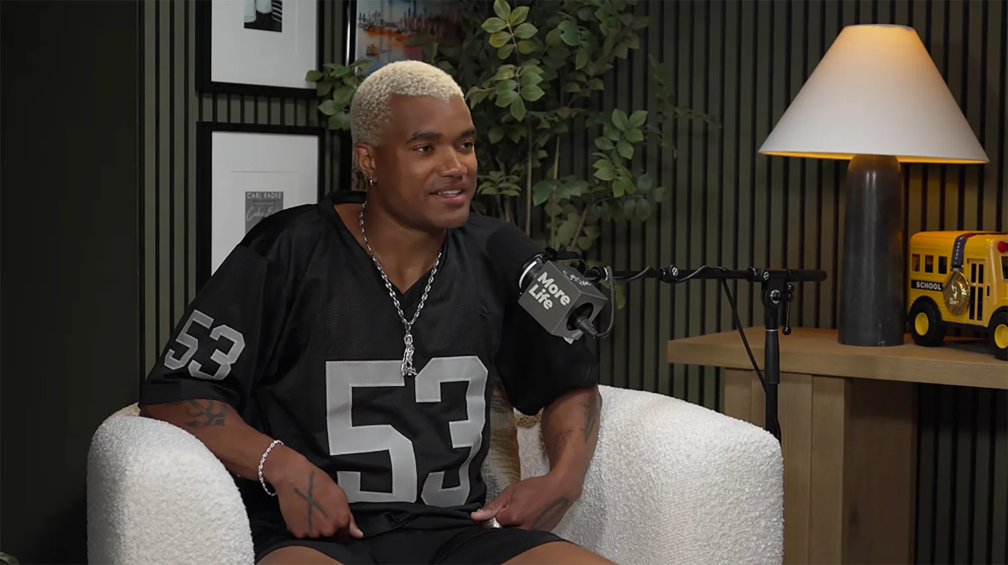 KJ Dillard in a black jersey with "53" on it, speaking into a "More Life" microphone.