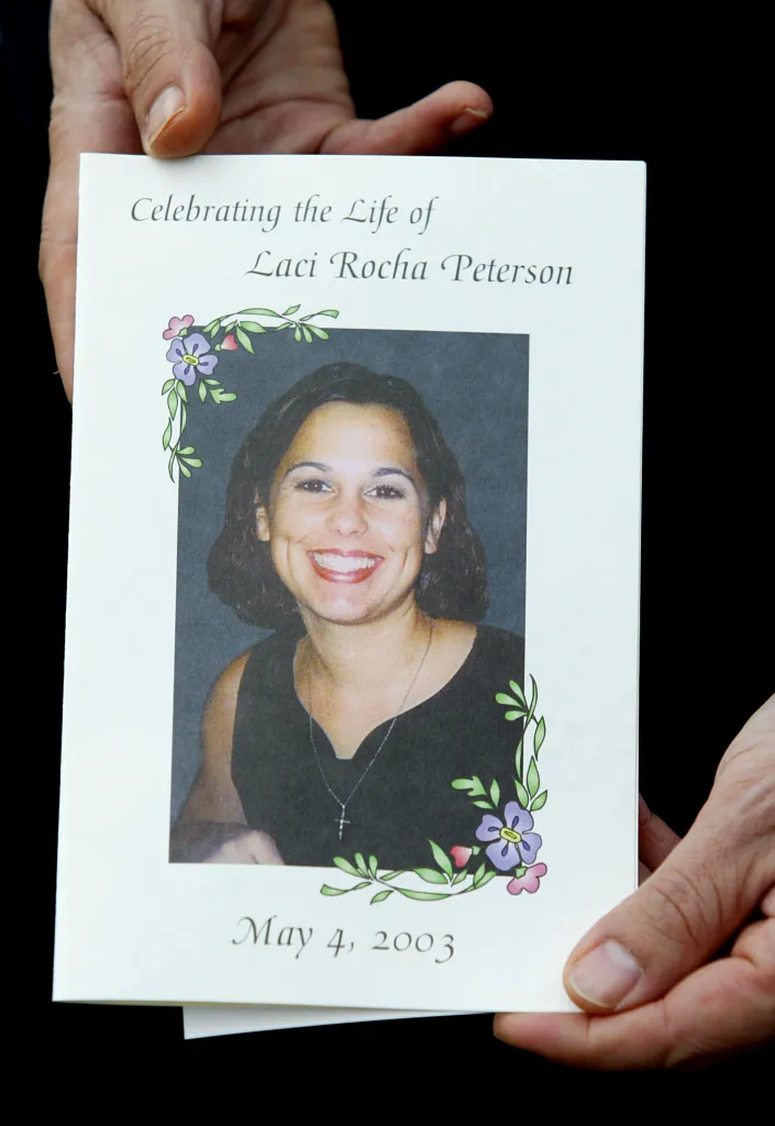 A person holding a memorial service program for Laci Rocha Peterson, featuring a smiling photo of her.