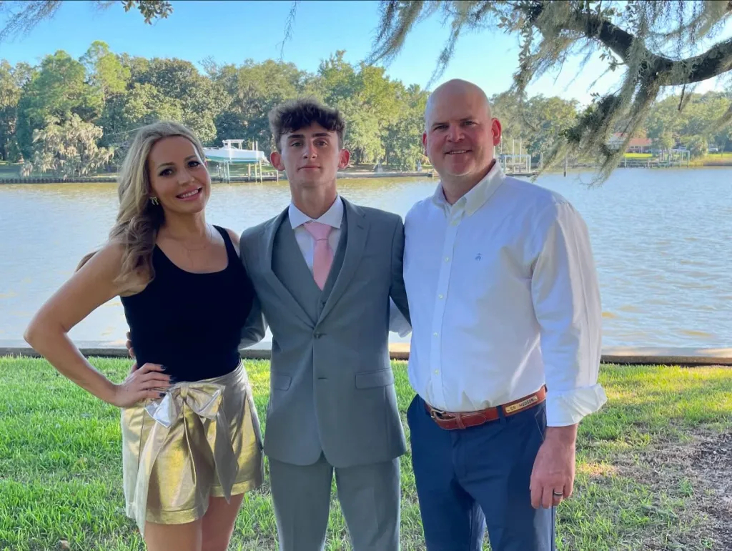 Ashlee Cole, Ben Hudson, and Warren Hudson posing by a lake.