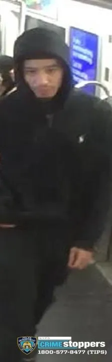 Suspect in a robbery case, wearing a black hooded sweatshirt with a white logo.