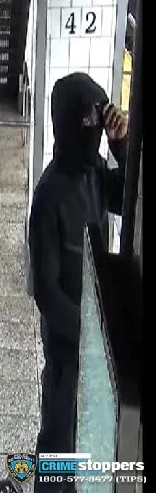 Robbery suspect in black hoodie and balaclava, partial view of his face.