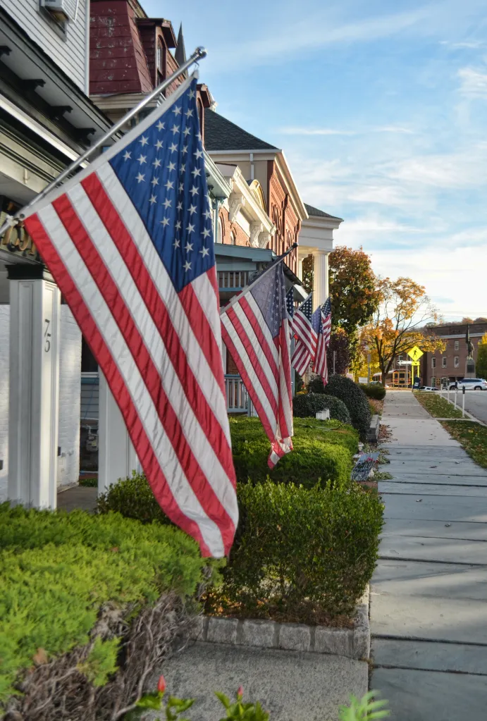 American flags are displayed in the front of houses.