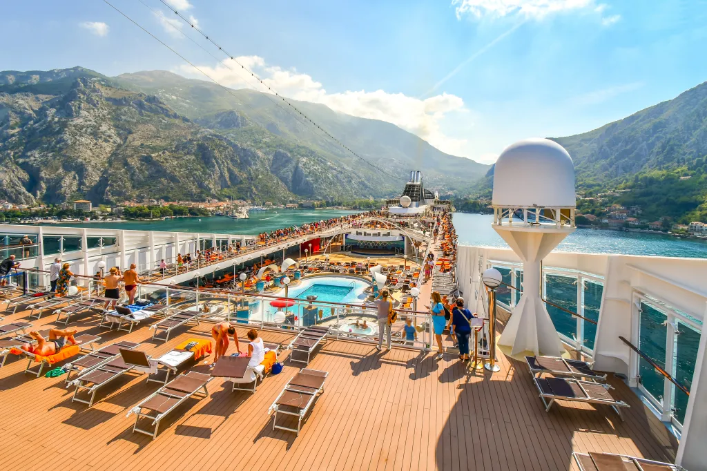 Tourists on a large cruise ship on Boka Bay near Perast heading towards the Kotor Montenegro cruise port on the Adriatic Sea.