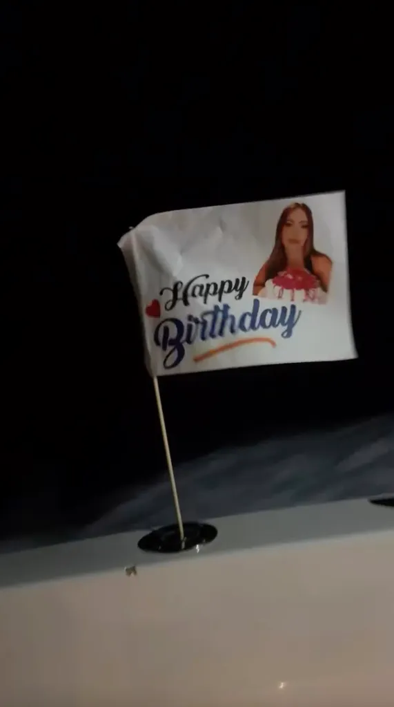 Happy Birthday flag with a photo of a woman holding a cake.
